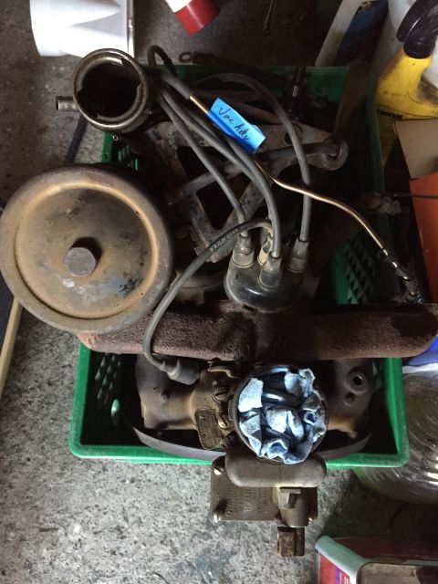 1946 Jeep Willys - Engine components are organized in a green plastic crate, awaiting further work or assembly.