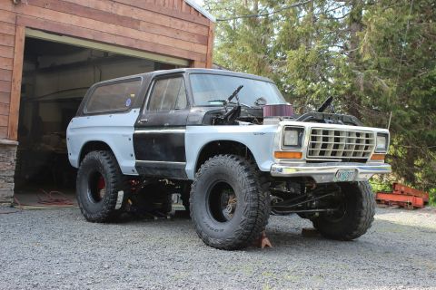 1979 Ford Bronco - This 1979 Ford Bronco is undergoing modifications, with its hood open and large off-road tires installed.