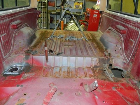1979 Ford Bronco - The interior of a 1979 Ford Bronco shows significant rust and is rigged with chains for what appears to be a repair or restoration project.