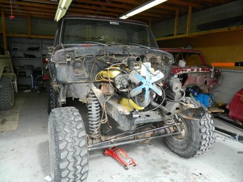 1979 Ford Bronco - This 1978 Ford Bronco is undergoing repairs in a garage, with its front end removed and engine visible.