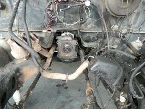 1979 Ford Bronco - Underside view of a vehicle's engine bay and transmission, with visible exhaust components and wiring harnesses.