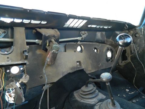 1979 Ford Bronco - The dashboard of a vehicle is shown with exposed wiring and a manual shifter, indicating a work in progress.