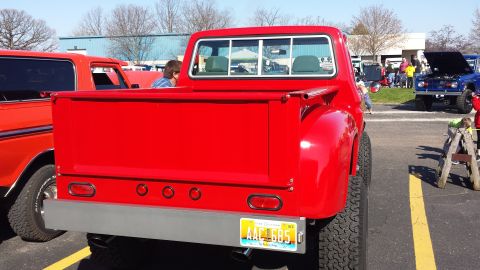 1995 Ford Bronco - Rear view of a red pickup truck at an outdoor event, with other vehicles visible.