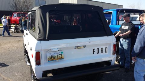 1995 Ford Bronco - This classic white Ford Bronco is displayed at an outdoor event with other vehicles.