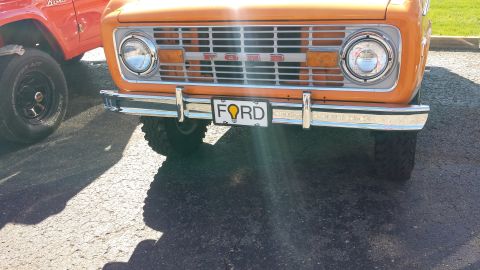1995 Ford Bronco - Front view of an orange Ford Bronco, its distinctive grille and a custom license plate.