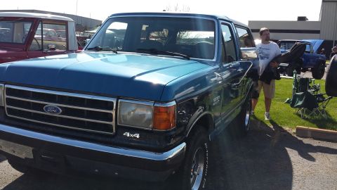 1995 Ford Bronco - Blue Ford Bronco with 4x4 badging is parked outdoors, with another Bronco visible behind it.
