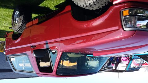 1995 Ford Bronco - This red SUV, likely from the early 1990s, is shown from a 3/4 front angle.