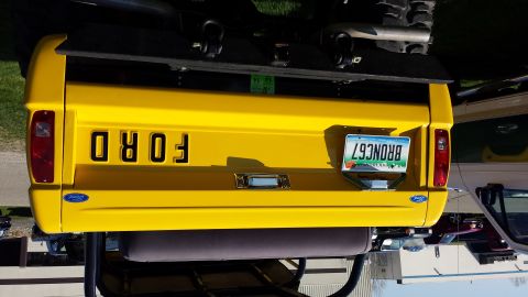 1995 Ford Bronco - Rear view of a yellow Ford Bronco, showing the tailgate and license plate.