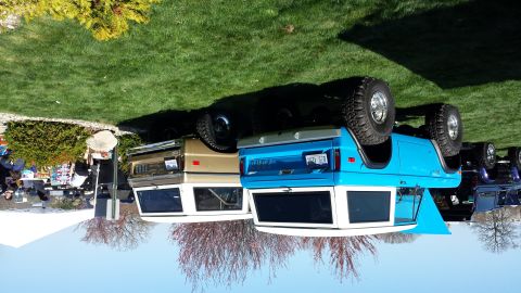1995 Ford Bronco - Two Ford Broncos, one blue and one tan, are parked next to each other on a grassy area.