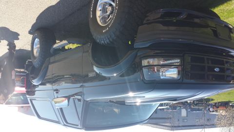 1995 Ford Bronco - This Ford Bronco is shown from the front quarter angle, highlighting its grille and headlights.