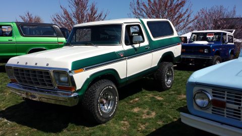 1995 Ford Bronco - This two-tone Ford Bronco is parked outdoors with other vehicles.