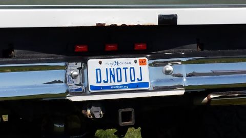 1995 Ford Bronco - The rear of a white vehicle shows a Michigan license plate with the custom text DJNOTOJ.