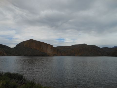 1995 Ford Bronco - Lake and mountains under a cloudy sky. Supermotors watermark visible in the lower right corner.