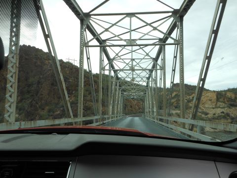 1995 Ford Bronco - The view from the driver's seat as the vehicle crosses a long, narrow metal bridge.