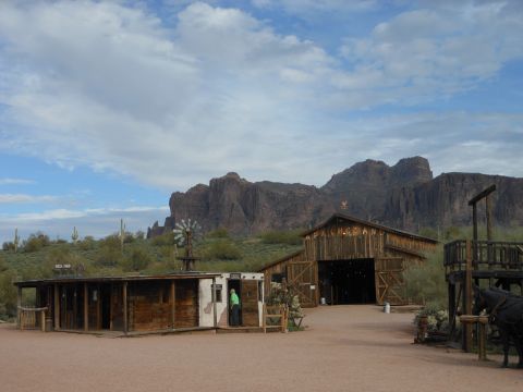 1995 Ford Bronco - A dusty western town scene unfolds with rustic buildings and a dramatic mountain backdrop under a cloudy sky.