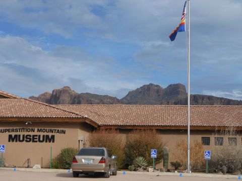 1995 Ford Bronco - The Superstition Mountain Museum is shown with a desert landscape and a single vehicle in the parking lot.