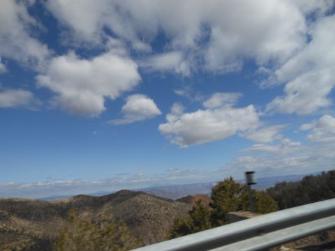1995 Ford Bronco - View of a vast mountain landscape with clouds, taken from a moving vehicle.