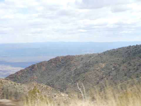 1995 Ford Bronco - View of a valley and mountains under a cloudy sky, with dry grass in the foreground.
