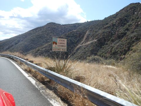 1995 Ford Bronco - A sign indicates the historic road to Jerome, Clarkdale, and Cottonwood, seen from a vehicle on a mountain road.
