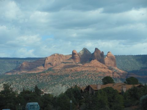 1995 Ford Bronco - A blue van is visible in the foreground, with a scenic view of red rock formations and a house in the background.