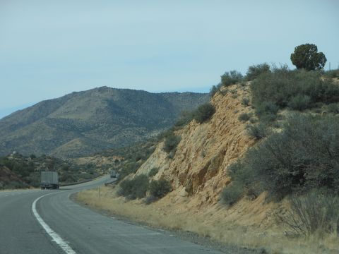 1995 Ford Bronco - Trucks travel along a highway that winds through a dry, rocky terrain with distant mountains.