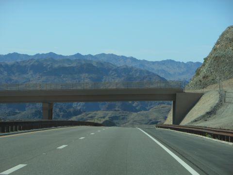 1995 Ford Bronco - A highway overpass spans a road in a vast, arid landscape under a clear blue sky.