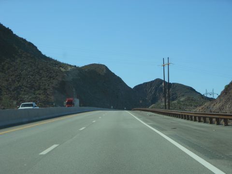 1995 Ford Bronco - Driving on a highway with mountains on either side and two vehicles ahead.