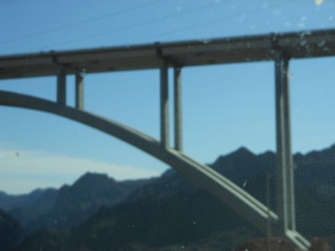 1995 Ford Bronco - A bridge spans across a mountainous landscape under a bright blue sky.
