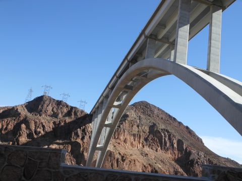 1995 Ford Bronco - A large concrete bridge spans a , mountainous terrain under a clear blue sky.