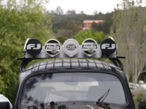 1964 Volkswagen Beetle - Roof rack fitted with five auxiliary lights, including FJ and Hella branding, is mounted on a vehicle.