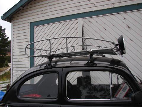 1964 Volkswagen Beetle - Side view of a black 1964 Volkswagen Beetle fitted with a roof rack and an auxiliary headlight.