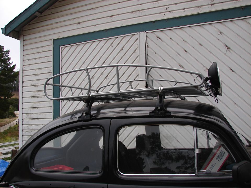 Black 1964 Volkswagen Beetle with a metal roof rack and a single headlight attached
