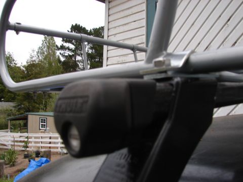 1964 Volkswagen Beetle - A close-up view of a black Thule roof rack mount and silver rack bar.