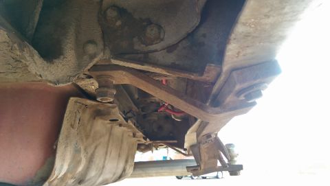 1978 Ford Bronco - Close-up of the vehicle's undercarriage, showing aged and corroded metal parts.