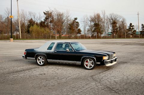 1985 Mercury Grand Marquis - A 1985 Mercury Grand Marquis coupe is shown from a three-quarter front angle in a parking lot.