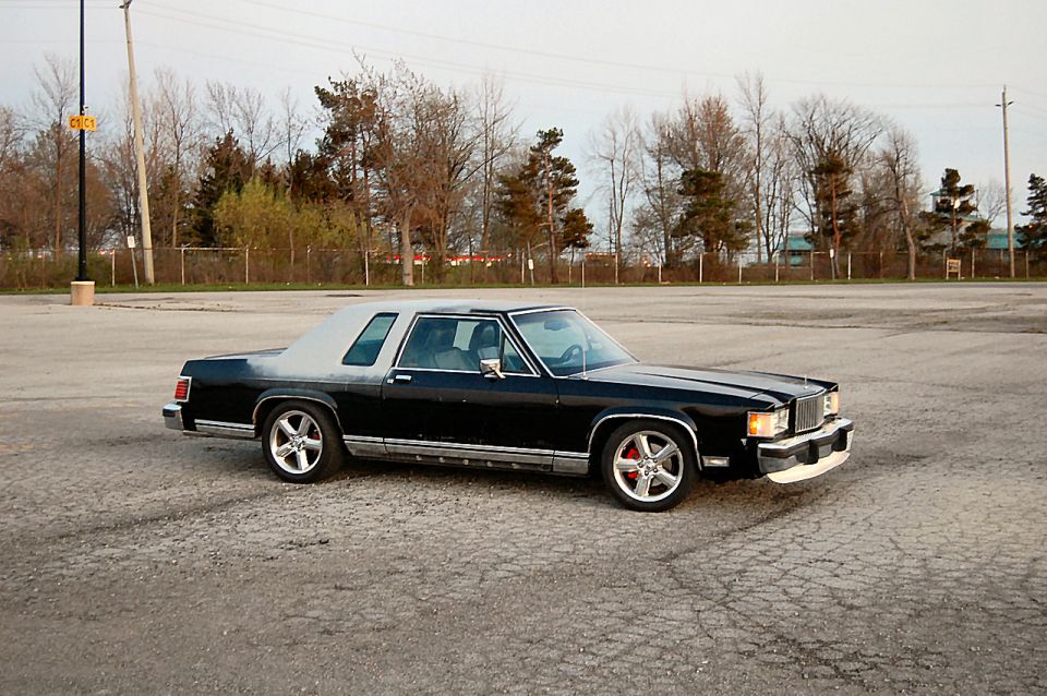 Black and grey 1985 Mercury Grand Marquis coupe with aftermarket wheels