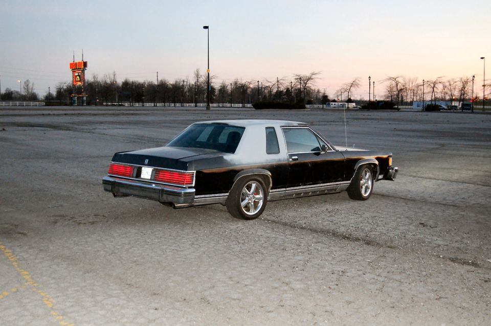 1985 Mercury Grand Marquis parked in an empty lot at dusk