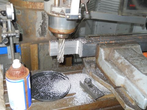 1992 Ford Bronco - A milling machine is actively cutting a metal workpiece, creating a significant amount of metal shavings.