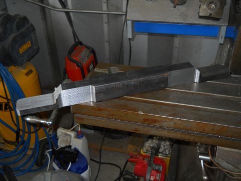 1992 Ford Bronco - A custom machined metal part rests on a workbench in a workshop setting.