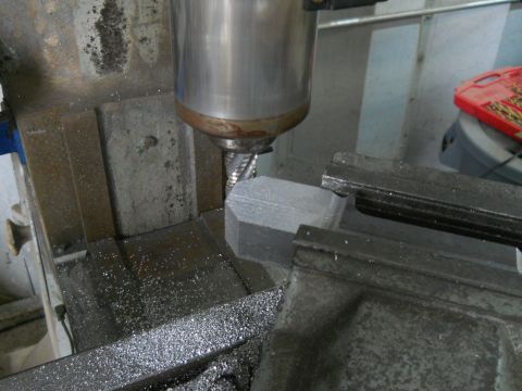 1992 Ford Bronco - A milling machine is actively cutting a metal component, creating shavings.