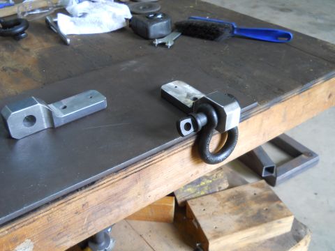 1992 Ford Bronco - Metal parts and tools are laid out on a workbench surface.
