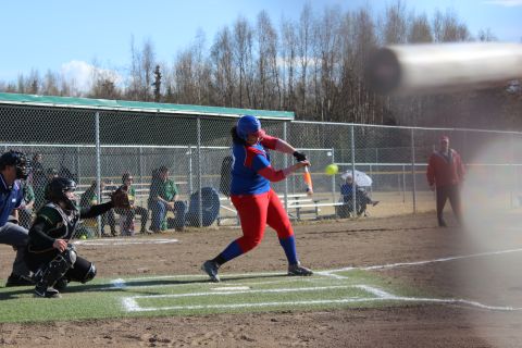 1990 Chevrolet Suburban - A batter attempts to hit a softball while a catcher waits behind home plate.