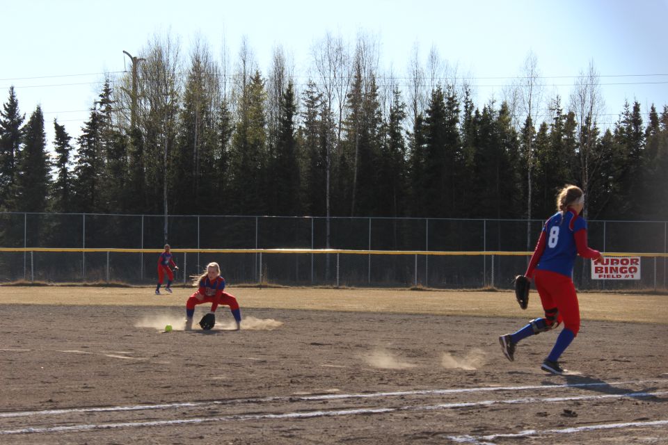 Softball players on field, one running, one fielding