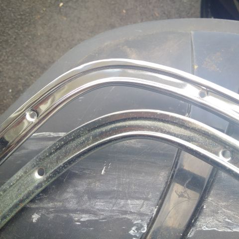 1978 Ford Bronco - Close-up of two chrome trim pieces, possibly for a vehicle's interior or exterior trim.