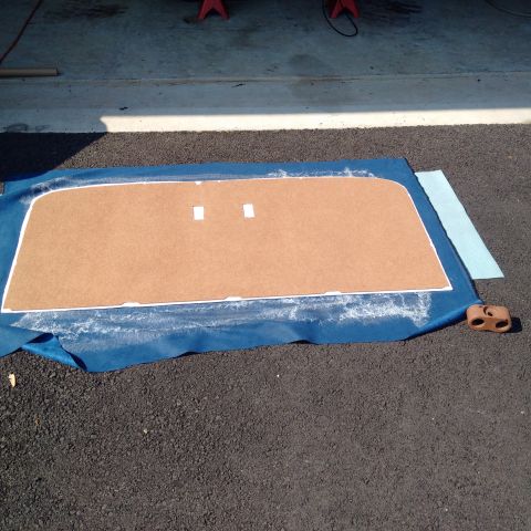 1978 Ford Bronco - Door panel material being prepared on a blue tarp, with white adhesive trim visible.