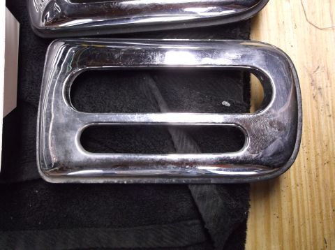 1999 Mercury Grand Marquis - Close-up view of two chrome trim pieces with visible scratches and wear.