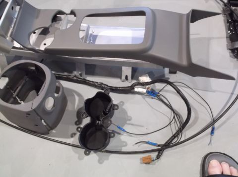 1999 Mercury Grand Marquis - Disassembled center console components, including trim pieces and a wiring harness, are laid out on a flat surface.