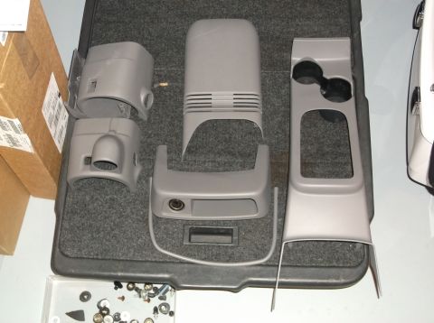 1999 Mercury Grand Marquis - Disassembled car interior console components are arranged on a carpeted floor.