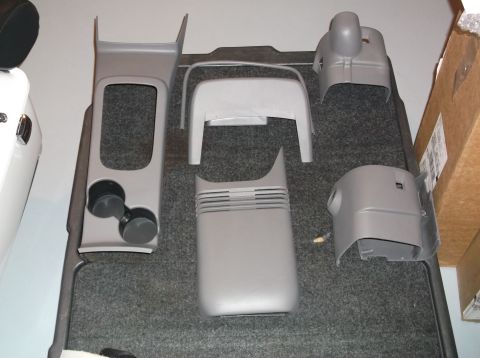 1999 Mercury Grand Marquis - Various interior plastic parts are displayed on a carpeted surface, possibly for installation or sale.