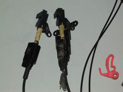 1999 Mercury Grand Marquis - Close-up of two electrical connectors and a red plastic clip against a plain background.
